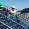 Homens Carregando Painel Solar - 5 Benefícios Que o Uso da Energia Solar Pode Trazer Para as Empresas